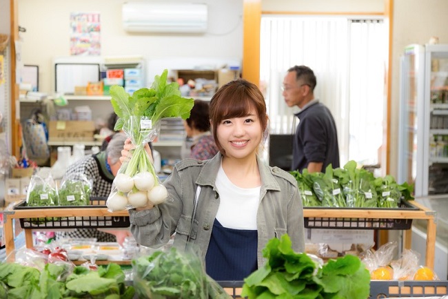 野菜を持ち上げる女性